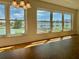 Bright room with large windows showing the outside view and sunlight shining on the hardwood floors at 1655 S Highland Ave # I286, Clearwater, FL 33756