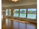 Bright living room featuring wood floors and expansive windows with a serene pond view at 1655 S Highland Ave # I286, Clearwater, FL 33756