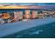 Stunning aerial view of beachfront condo towers with city skyline and ocean sunset backdrop at 17920 Gulf Blvd # 2004, Redington Shores, FL 33708