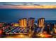 Aerial view showcasing beachfront condo towers, parking, and a pool at dusk at 17920 Gulf Blvd # 2004, Redington Shores, FL 33708