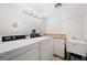 Clean laundry room featuring a utility sink, countertop, updated appliances, and ample lighting at 17920 Gulf Blvd # 2004, Redington Shores, FL 33708