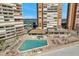 Aerial view of a community pool with lounge chairs between condo buildings near the beach at 17920 Gulf Blvd # 2004, Redington Shores, FL 33708