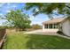 Well-manicured backyard with a view of the enclosed porch and a fenced perimeter at 18241 Autumn Lake Blvd, Hudson, FL 34667