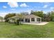 Wide shot of the backyard, highlighting the extensive lawn, concrete patio, and screened-in porch at 18241 Autumn Lake Blvd, Hudson, FL 34667
