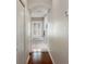 Hallway leading to bathroom with wood flooring and a glimpse of the tub with shuttered window at 18241 Autumn Lake Blvd, Hudson, FL 34667