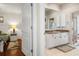 Bright bathroom featuring white cabinetry with granite counters and views into the main bedroom at 18241 Autumn Lake Blvd, Hudson, FL 34667