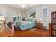 Bright bedroom featuring a ceiling fan, shuttered windows, and a decorative ocean-themed painting at 18241 Autumn Lake Blvd, Hudson, FL 34667