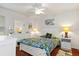 Well-lit bedroom featuring light walls, wood floors, a ceiling fan, and colorful floral bedspread at 18241 Autumn Lake Blvd, Hudson, FL 34667
