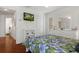 Bedroom with light walls, wood floors, TV, a ceiling fan, and multiple windows for natural light at 18241 Autumn Lake Blvd, Hudson, FL 34667