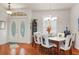 Bright dining room with a decorative glass insert in the front door and a dining table with white leather chairs at 18241 Autumn Lake Blvd, Hudson, FL 34667