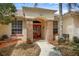 Attractive front entrance with a decorative red door, brick accents, and well-maintained landscaping at 18241 Autumn Lake Blvd, Hudson, FL 34667
