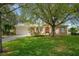 Charming single-story home boasts a well-manicured lawn and beautiful landscaping with mature trees at 18241 Autumn Lake Blvd, Hudson, FL 34667