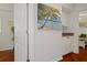 Hallway showing small serving bar, door to bedroom, and decor of palm tree art at 18241 Autumn Lake Blvd, Hudson, FL 34667