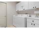 Bright laundry room with white washer and dryer, cabinets, and sink for added convenience at 18241 Autumn Lake Blvd, Hudson, FL 34667