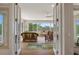 Living room featuring wicker furniture, wood flooring, and large picture windows with scenic views at 18241 Autumn Lake Blvd, Hudson, FL 34667
