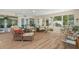 Bright sunroom features wicker furniture and hardwood flooring with views of the landscaped back yard at 18241 Autumn Lake Blvd, Hudson, FL 34667