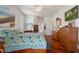 Bright main bedroom with tropical bedding, wood floors, and a television for relaxing evenings at 18241 Autumn Lake Blvd, Hudson, FL 34667