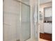 Walk in shower with glass door, with adjacent room featuring cabinets and granite counters at 18241 Autumn Lake Blvd, Hudson, FL 34667