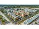 Wide aerial view of a dense orange condo community surrounded by green space and parking lots at 1900 68Th N St # 110, St Petersburg, FL 33710