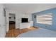Well-lit bedroom featuring wood flooring, a TV, and blue accent wall at 1900 68Th N St # 110, St Petersburg, FL 33710