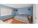 A well lit bedroom with a queen sized bed, wood floors, and blue walls at 1900 68Th N St # 110, St Petersburg, FL 33710