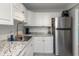 The contemporary kitchen boasts a stainless steel refrigerator, granite countertops, and well-lit white cabinets at 1900 68Th N St # 110, St Petersburg, FL 33710