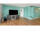 View of a living room featuring a sleek entertainment center and a lively turquoise accent wall that enhances the room's appeal at 1900 68Th N St # 110, St Petersburg, FL 33710