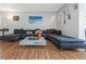 Comfortable living room featuring modern decor, a large sectional, and wood floors at 1900 68Th N St # 110, St Petersburg, FL 33710