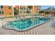 Rectangular community pool has a shallow end and is surrounded by orange buildings and blue lounge chairs at 1900 68Th N St # 110, St Petersburg, FL 33710