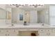 Well-lit bathroom featuring double sinks, white cabinets, and a large decorative mirror at 2159 Warwick Dr, Oldsmar, FL 34677
