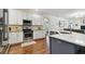 Bright kitchen featuring white cabinets, stainless steel appliances, and hardwood floors at 2159 Warwick Dr, Oldsmar, FL 34677
