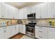 Kitchen boasting white cabinets, a stylish backsplash, and stainless steel appliances at 2159 Warwick Dr, Oldsmar, FL 34677