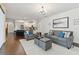 Open-concept living room featuring hardwood floors, plush seating, and a modern chandelier at 2159 Warwick Dr, Oldsmar, FL 34677