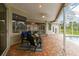 Covered patio with brick flooring, comfortable seating, and a view of the screened pool area at 2159 Warwick Dr, Oldsmar, FL 34677