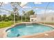 Beautiful screened-in pool with a waterfall feature and tranquil backyard surroundings at 2159 Warwick Dr, Oldsmar, FL 34677