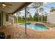 Screened-in pool with waterfall feature, brick pavers, and a serene backyard view at 2159 Warwick Dr, Oldsmar, FL 34677