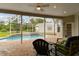 Inviting screened-in pool with waterfall feature, brick patio, and outdoor seating at 2159 Warwick Dr, Oldsmar, FL 34677