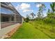 Green lawn extends from the house to the natural Florida landscape, offering a spacious outdoor area at 2159 Warwick Dr, Oldsmar, FL 34677