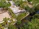 Aerial view of home with screened-in pool and canal front lot with mature tropical landscaping for privacy at 219 Rialto Ne Way, St Petersburg, FL 33704
