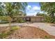 Charming single-story home with mature trees and a spacious driveway leading to a two-car garage at 219 Rialto Ne Way, St Petersburg, FL 33704