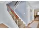 Staircase with carpeted steps, white risers, and a stained wood handrail leads upstairs at 2647 Barksdale Ct, Clearwater, FL 33761
