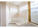 Bathroom featuring a soaking tub, tiled walls, and a glass enclosed shower with gold trim at 3027 Key Harbor Dr, Safety Harbor, FL 34695