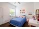 Bedroom with dark floors, white walls, window, comfy bed, wall decor, and a desk with a vanity mirror at 3027 Key Harbor Dr, Safety Harbor, FL 34695