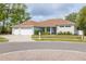 Charming home featuring a three-car garage, well-maintained lawn, and mature trees in a serene neighborhood at 3027 Key Harbor Dr, Safety Harbor, FL 34695