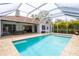 Stunning view of screened-in pool, outdoor dining space, and partial view of home's exterior at 3027 Key Harbor Dr, Safety Harbor, FL 34695