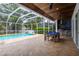 Spacious screened-in pool area with travertine tile and a game area at 3027 Key Harbor Dr, Safety Harbor, FL 34695