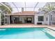 A sparkling blue screened-in pool with an outdoor dining area, and seamless indoor-outdoor living at 3027 Key Harbor Dr, Safety Harbor, FL 34695