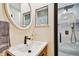 Updated bathroom featuring a wood vanity, round mirror, and a glass-enclosed shower with modern fixtures at 315 Medallion Blvd # E, Madeira Beach, FL 33708
