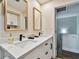 Bright bathroom featuring a dual sink vanity, elegant mirrors, and contemporary fixtures at 315 Medallion Blvd # E, Madeira Beach, FL 33708