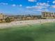 Stunning aerial view of a beach with clear water, beachfront buildings, and people enjoying the outdoors at 315 Medallion Blvd # E, Madeira Beach, FL 33708